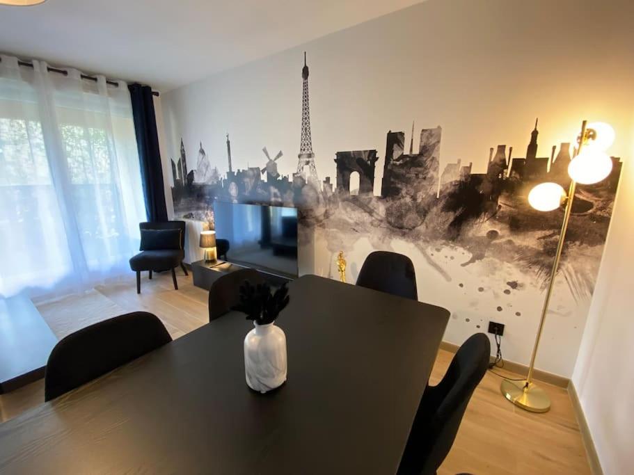 a dining room with a table with a vase of flowers on it at Disneyland Dream 6 - Charmant Appartement 8 pax in Montévrain