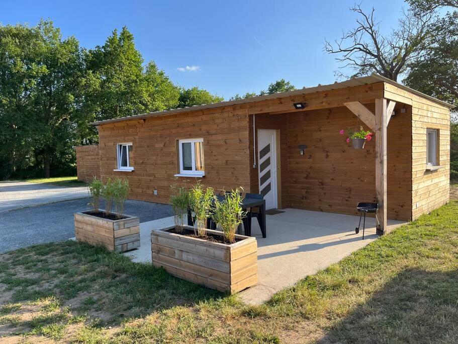 ein kleines Holzgebäude mit einem Picknicktisch davor in der Unterkunft Les Chalets du Mancel - Chalet Tennessee - 500 m Bouleries Jump , 10 min du circuit des 24h in Parence