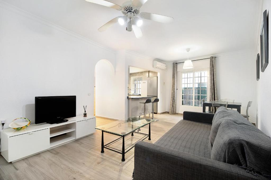 a living room with a couch and a flat screen tv at Apartamento Ribera del Marisco in El Puerto de Santa María