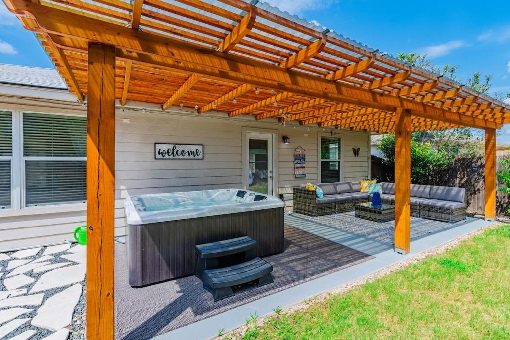 a patio with a hot tub under a wooden pergola at Luxury Oasis Hot-tub, Games & Bbq By Fiesta Tx in San Antonio
