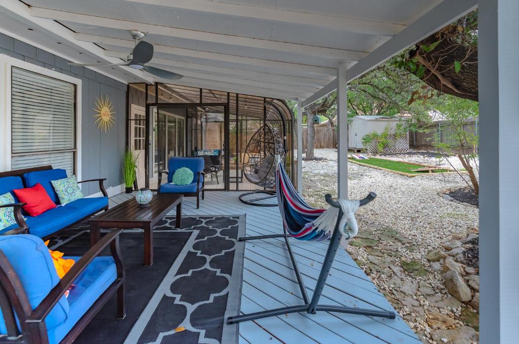 a porch with a hammock and a table and chairs at Beautiful Home With Sunroom, Gameroom, Yard & Bbq in San Antonio