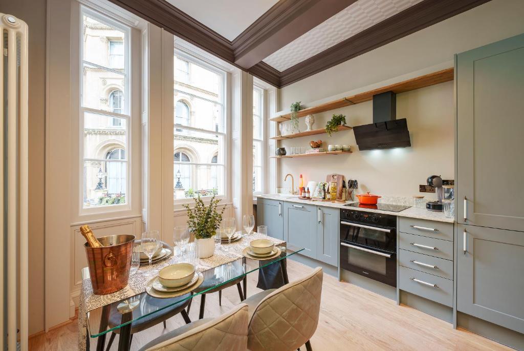 uma cozinha com uma mesa e algumas janelas em The Florin - 1 Bedroom Apartment in Central Bristol by Mint Stays em Bristol