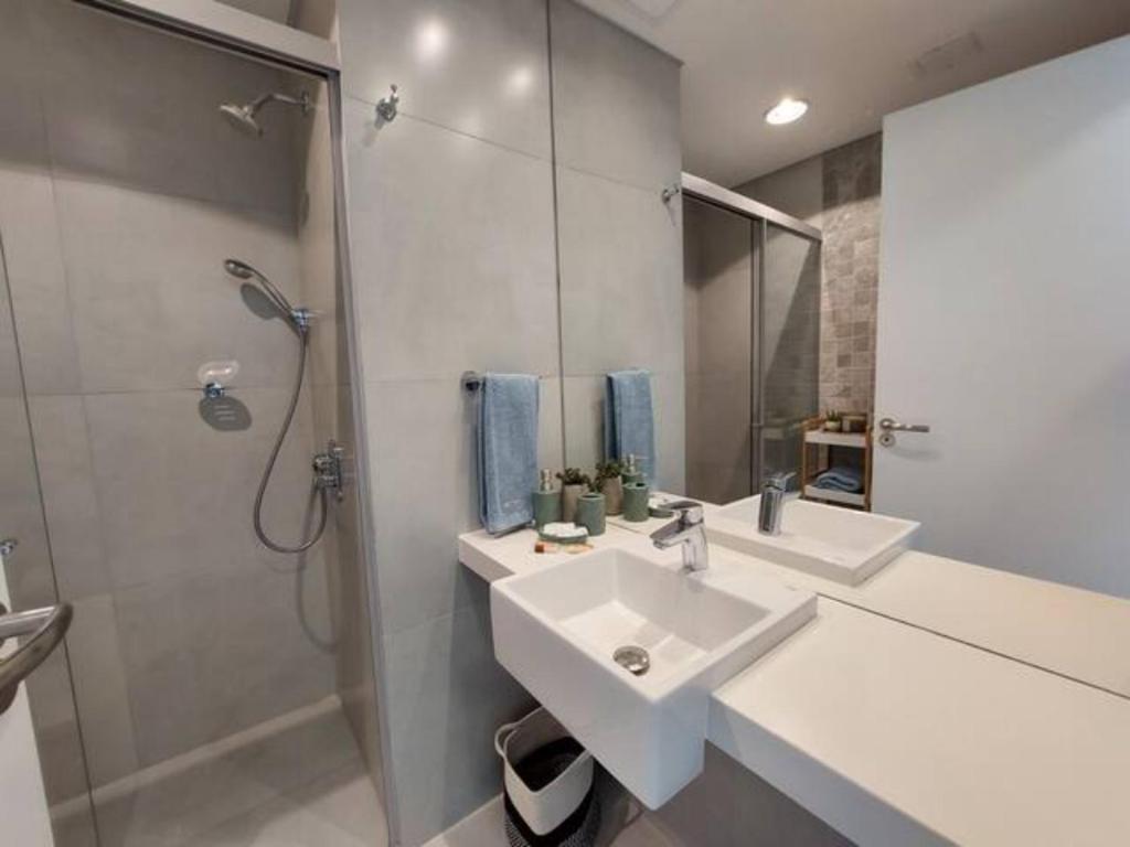 a white bathroom with a sink and a shower at Edificio IN 1362 MOLAS in Asuncion