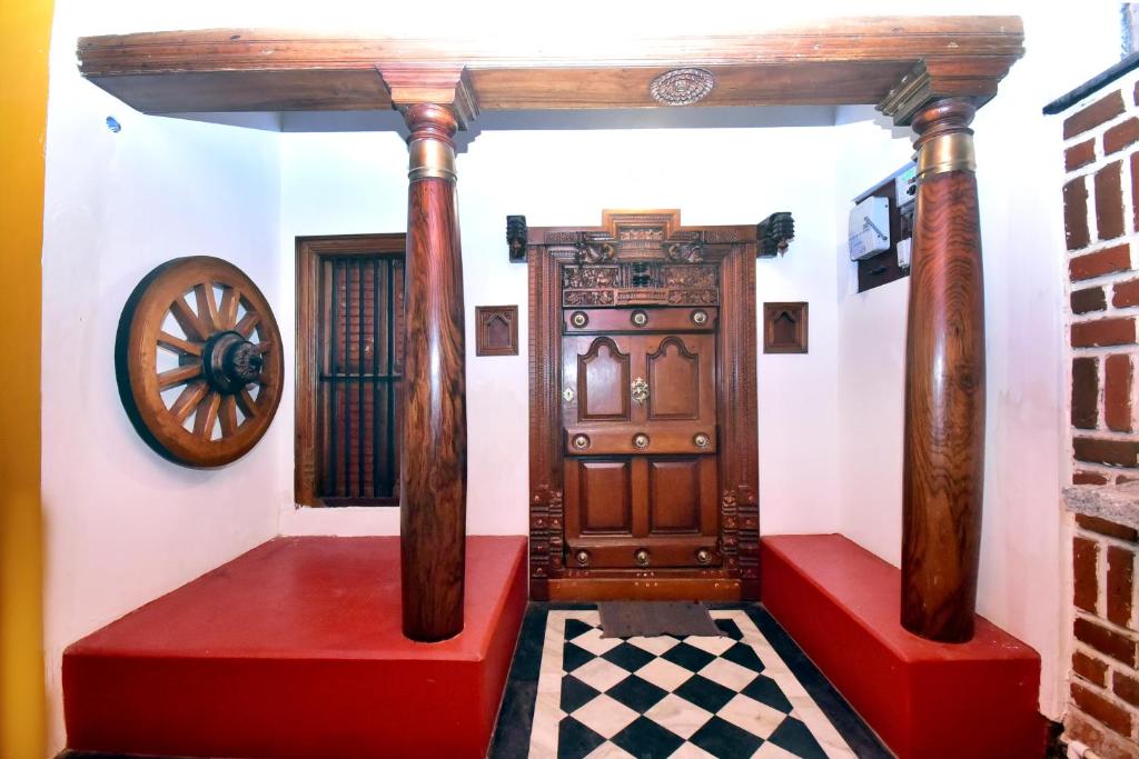 a room with a wooden door and a checkered floor at Villa D Jems -A Heritage Home stay in Puducherry