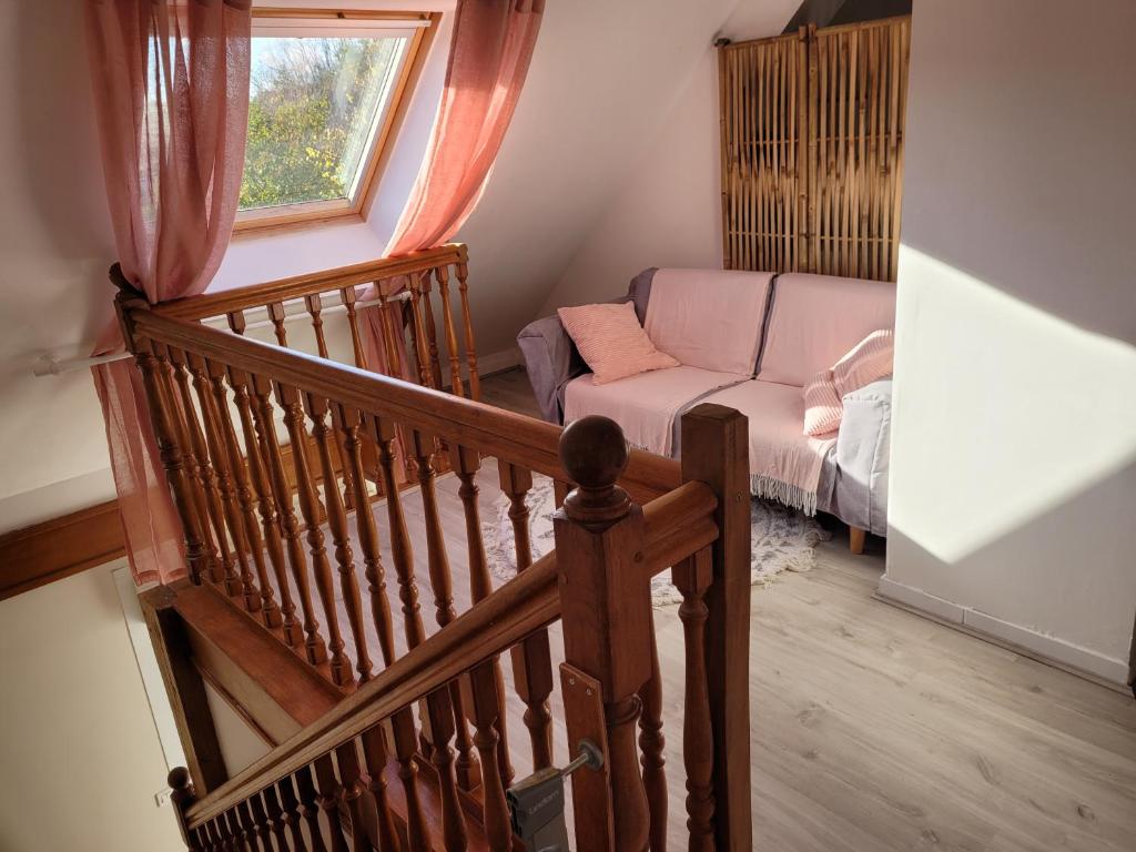 a staircase leading to a living room with a couch at Gîte Évasion idyllique à l&#39;étage près zoo-chateaux in Faverolles-sur-Cher