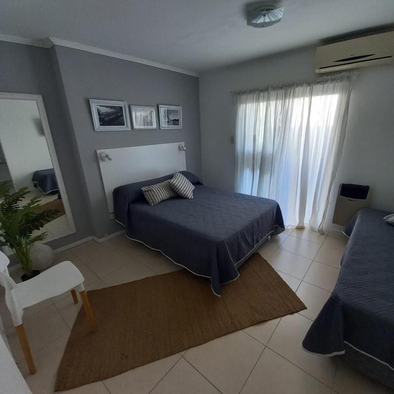 a bedroom with a bed and a couch and a window at Dpto Estudio in Gualeguaychú