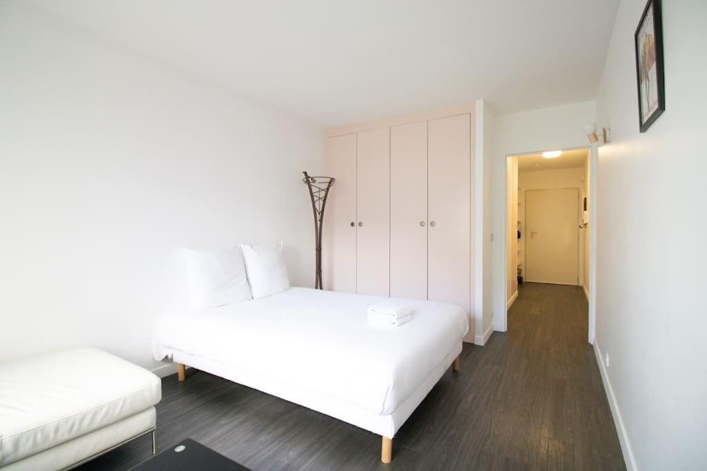 a white bedroom with two beds and a closet at Studio#Gare Montparnasse#Galeries Lafayette#2pers. in Paris