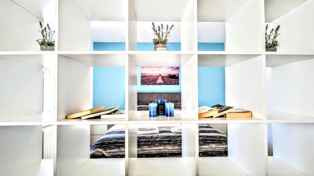 een slaapkamer met blauwe muren en witte planken bij Blue Lagoon 150m-2 minuta hoda od centra, mogucnost za parking-apartmani-nsmilos in Novi Sad