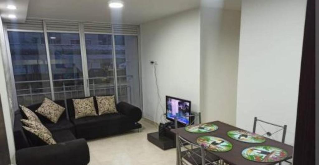 ein Wohnzimmer mit einem Sofa und einem Tisch in der Unterkunft Hermoso apartamento con excelente ubicación in Ibagué