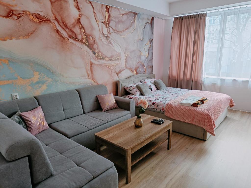 uma sala de estar com um sofá e uma cama em Apartamenty Centrum- Wojska Polskiego em Słupsk