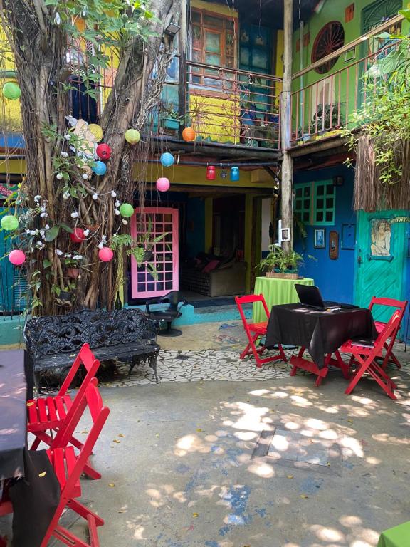 a group of red chairs and tables in front of a building at Pousada Babel in Rio de Janeiro