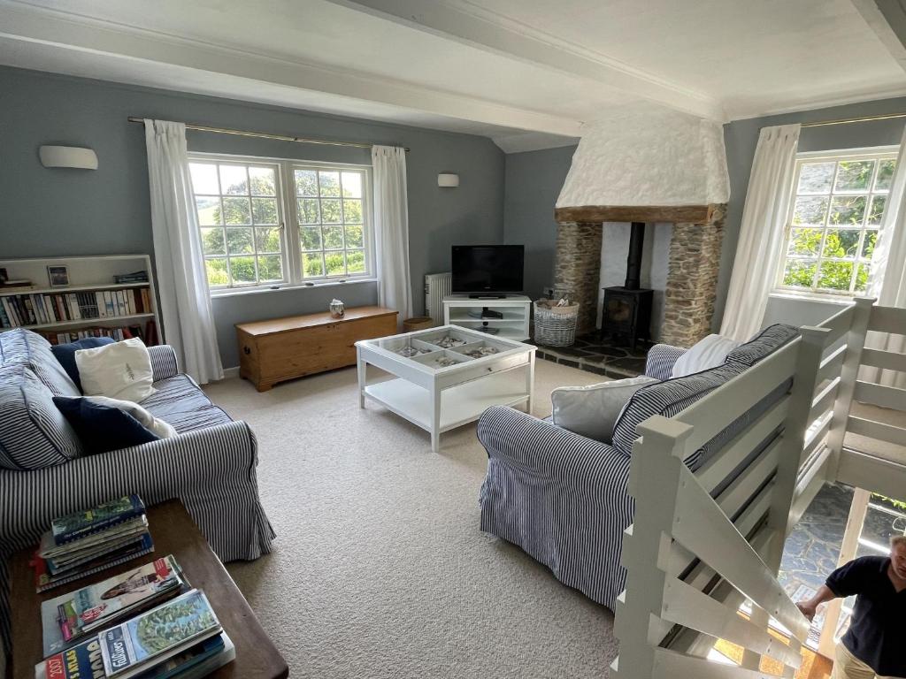 a living room with two couches and a fireplace at Little Crugsillick in Veryan