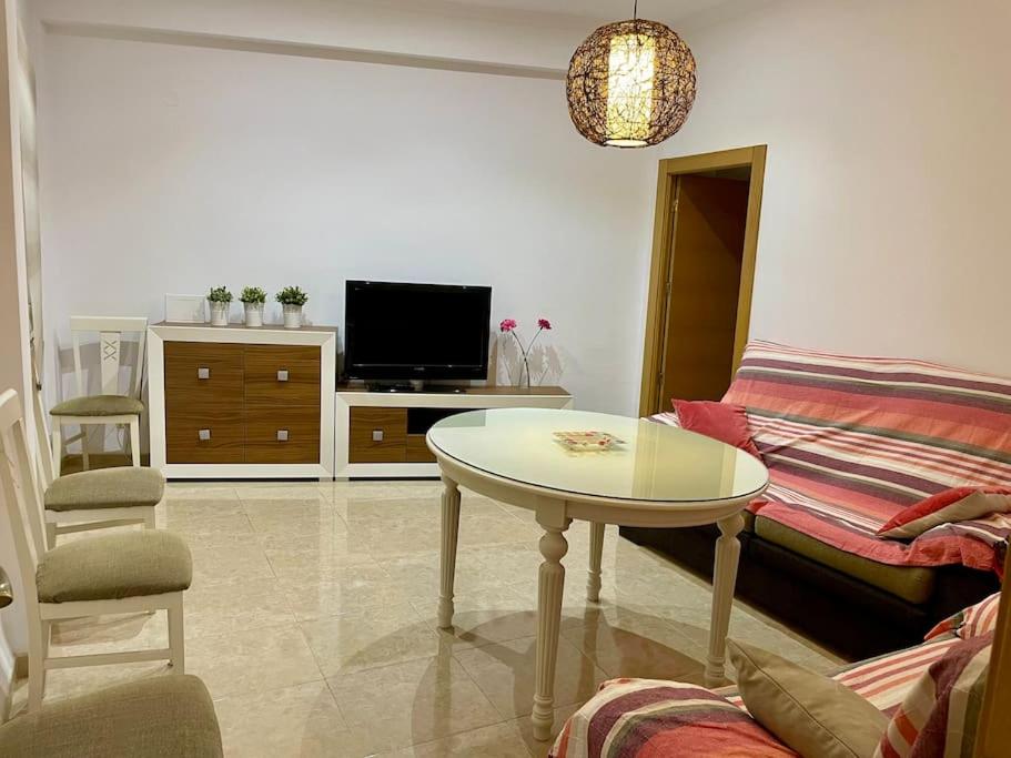 een woonkamer met een tafel en een bank bij Apartamento Almogávares in Córdoba