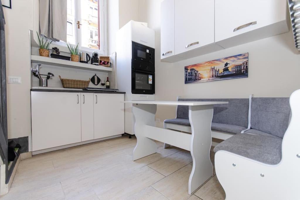 biała kuchnia ze stołem i krzesłem w obiekcie Appartamento Cadorna w Mediolanie