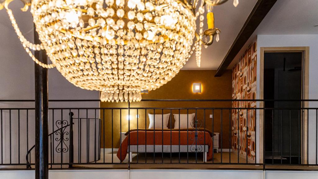 a bedroom with a large chandelier and a bed at Le Chouette Loft in Dijon