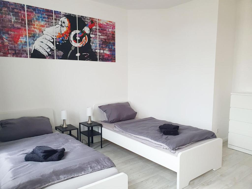 2 Betten in einem Zimmer mit Wandgemälde in der Unterkunft Work & Stay in Wismar in Wismar