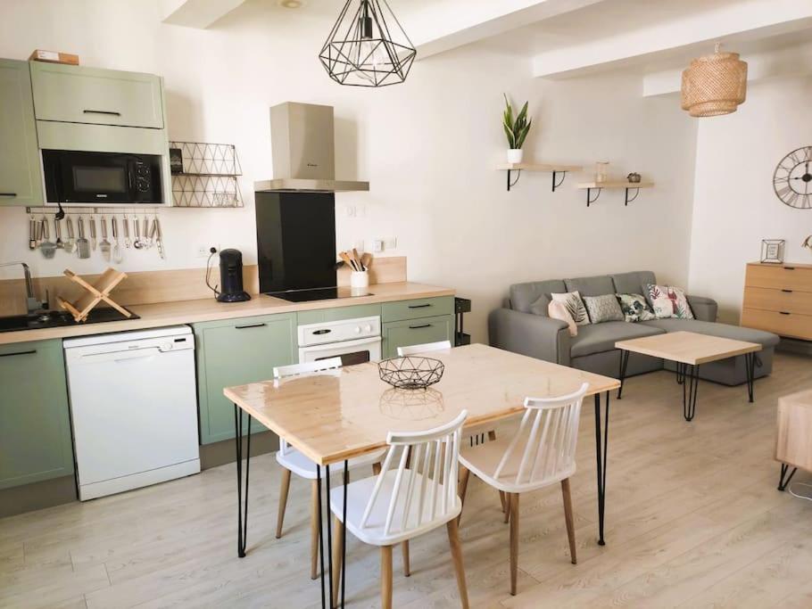 eine Küche und ein Wohnzimmer mit einem Tisch und Stühlen in der Unterkunft Charmant appartement entier 4 pers proche Aix in Gardanne