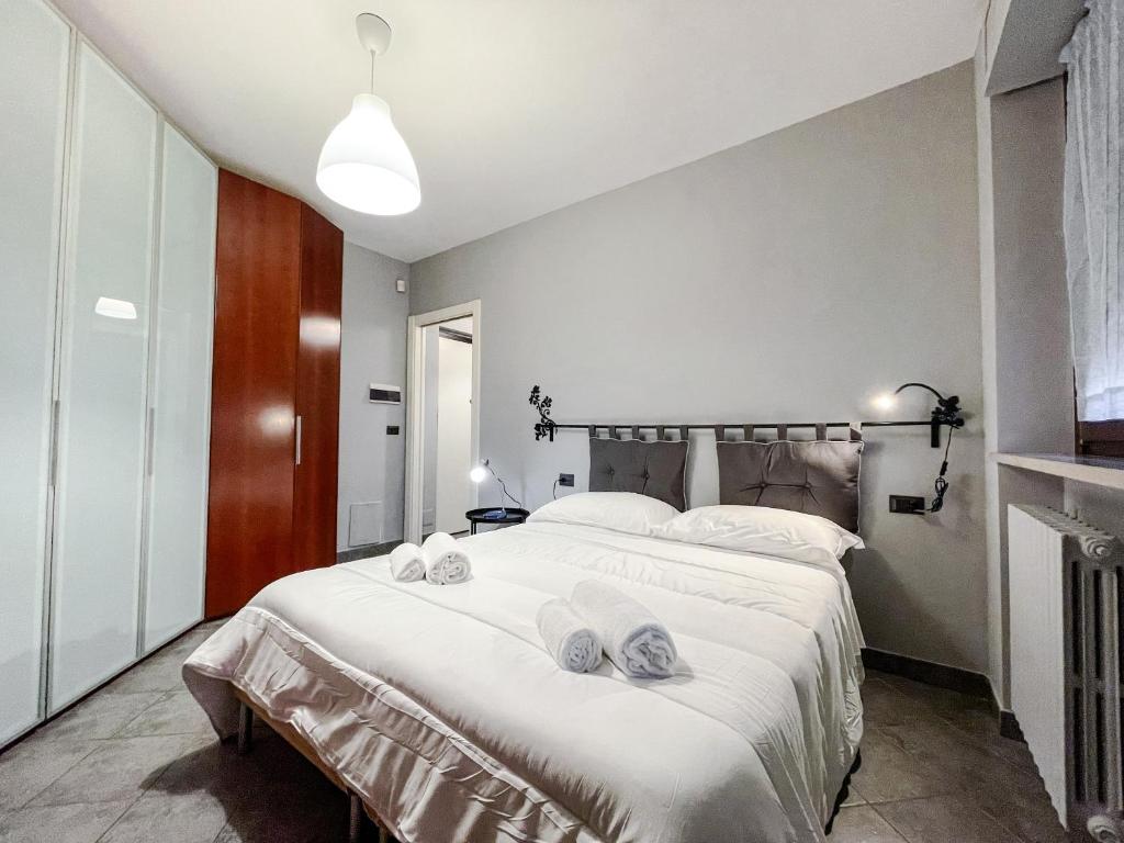 1 dormitorio con 1 cama blanca grande y toallas. en MYHOUSE INN FERMATA PARADISO - Affitti Brevi Italia, en Collegno