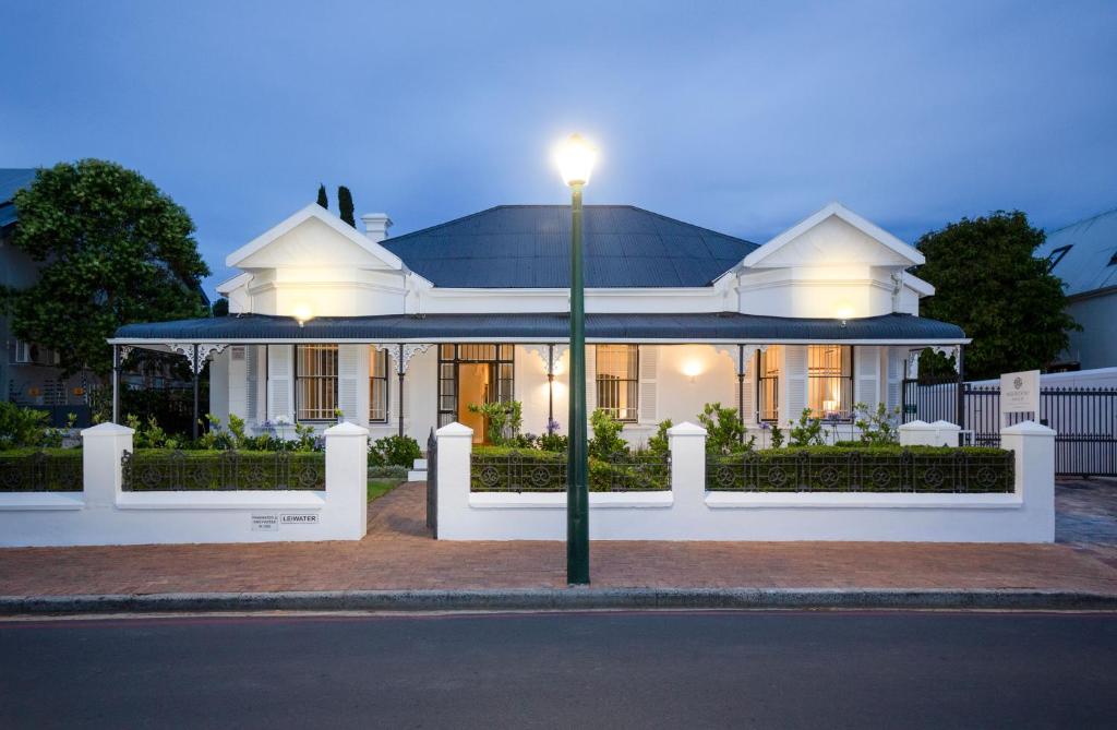 a white house with a light pole in front of it at Middedorp Manor in Stellenbosch