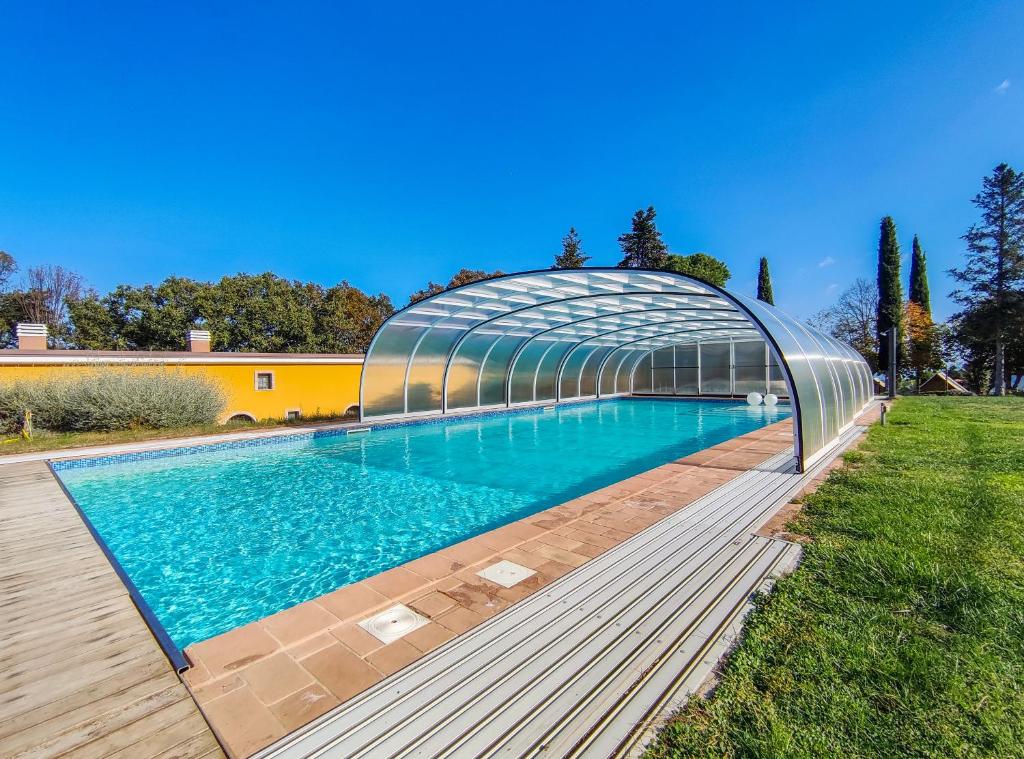 una piscina con un puente de cristal sobre ella en Poggio Imperiale Marche - Apartments & Glamping & Bubble Rooms, en Civitanova Marche