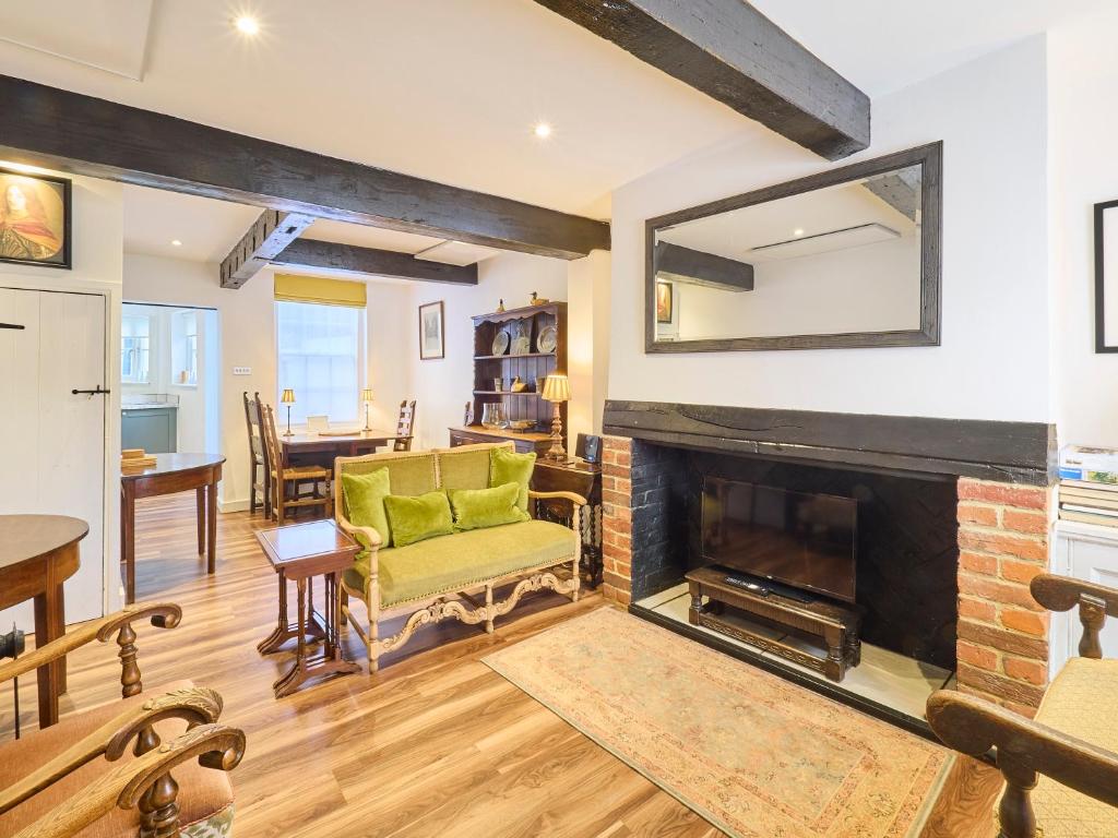 a living room with a fireplace and a green chair at Host & Stay - St Radigunds House in Canterbury