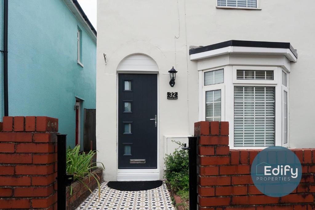 a blue and white house with a black door at Modernised House Close To City Centre in Southampton