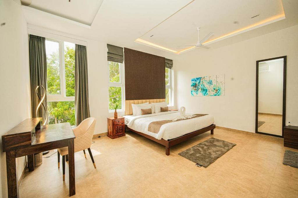 a hotel room with a bed and a desk and a desk at Shelter Beach Resort in Mahabalipuram