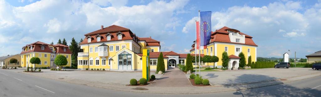 una grande casa gialla sul lato di una strada di Gasthof Hotel Jägerwirt a Strasswalchen