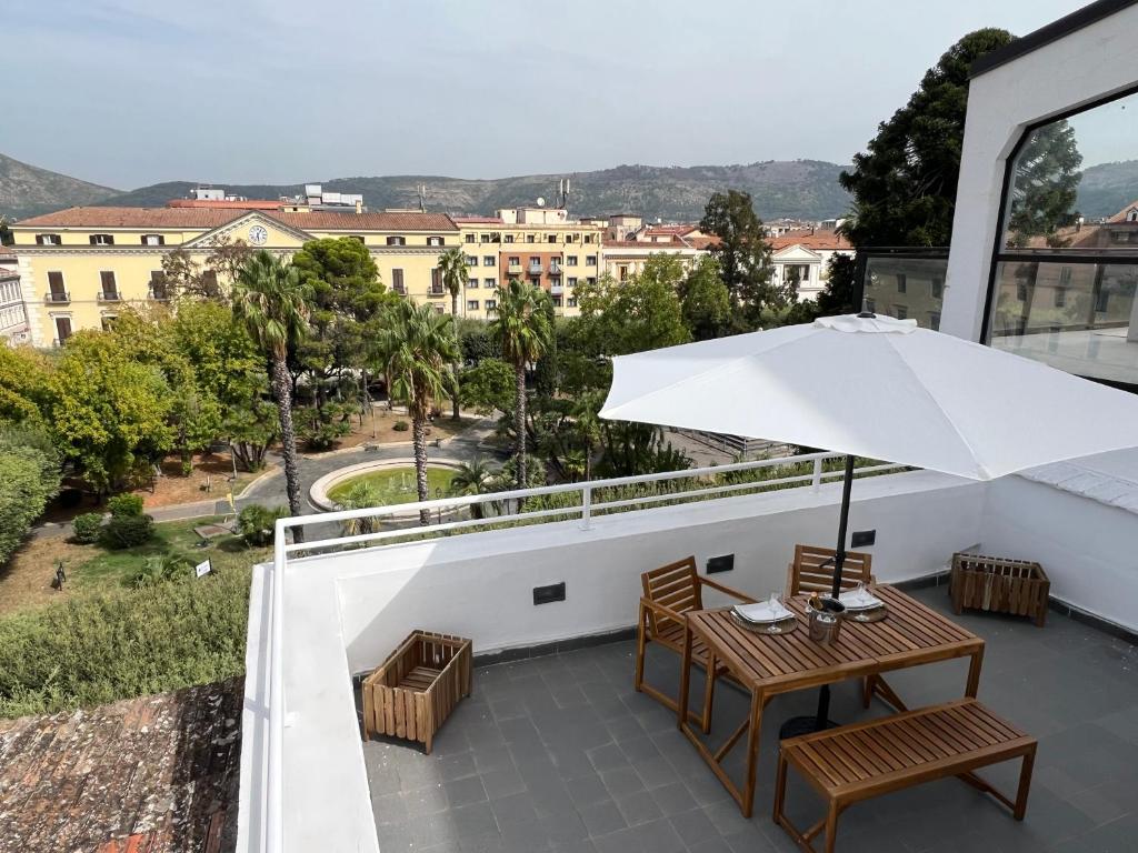uma varanda com uma mesa e cadeiras e um guarda-sol em Terrazza Vanvitelli em Caserta