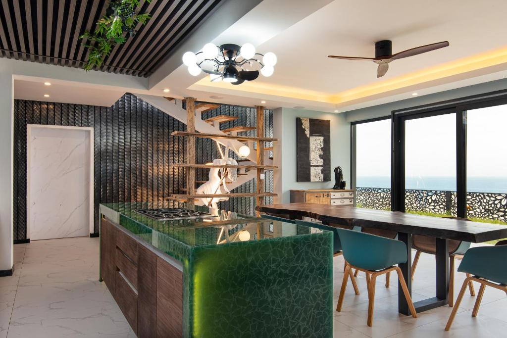 uma cozinha em plano aberto com mesa e cadeiras e vista para o oceano em FlamencoAccommodation em Ballito