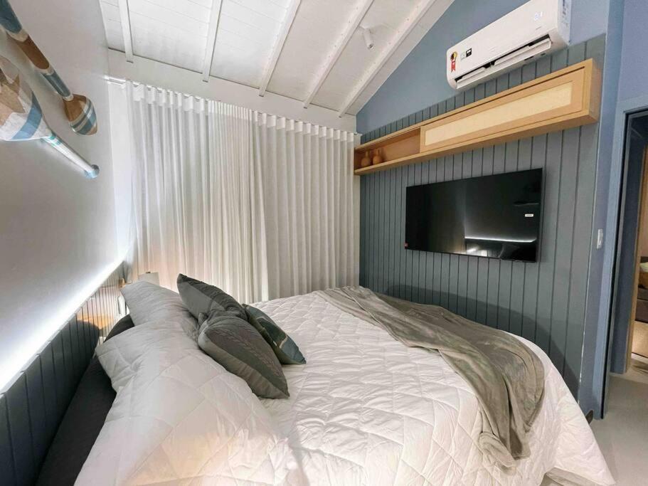 Schlafzimmer mit einem Bett und einem TV an der Wand in der Unterkunft Praia do Forte Lodge in Mata de Sao Joao