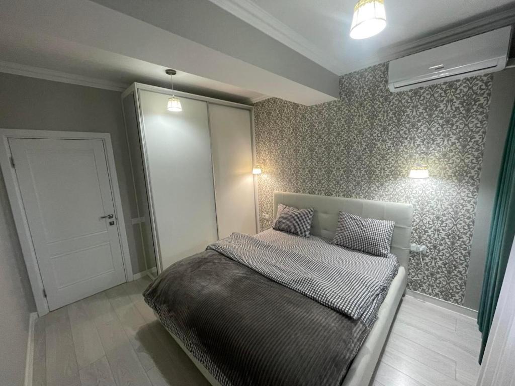 a bedroom with a bed in a room with a door at Комфортабельная квартира на улице Василе Лупу in Chişinău