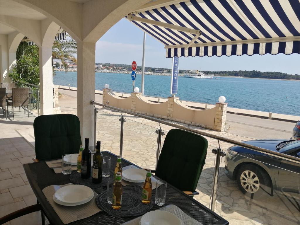 uma mesa e cadeiras com vista para a água em Apartment Romana - next to the sea em Novalja