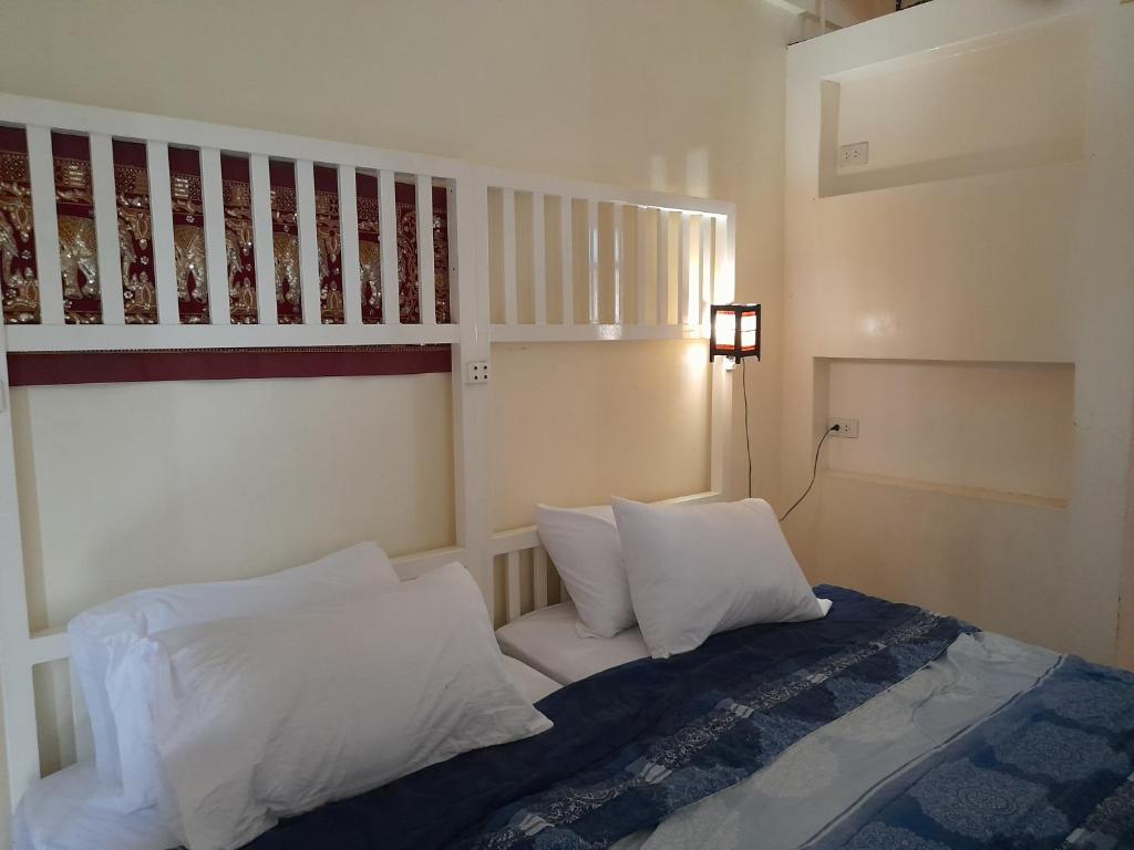 sypialnia z łóżkiem z białymi poduszkami i poddaszem w obiekcie 59Indyhouse w mieście Bangkok
