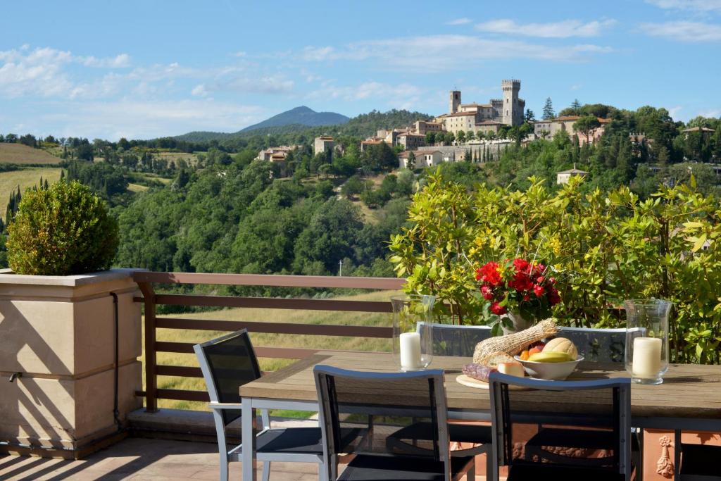 una mesa y sillas en un balcón con vistas en Fonteliving, en San Casciano dei Bagni
