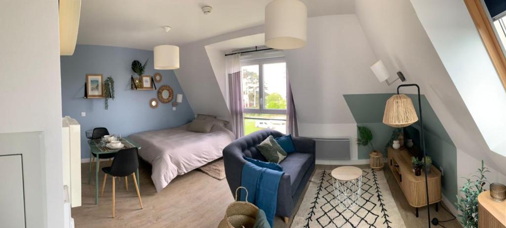 普雷讷夫昂德雷Studio proche de la mer à Pléneuf-Val-André的客厅里有一张蓝色沙发和一张床