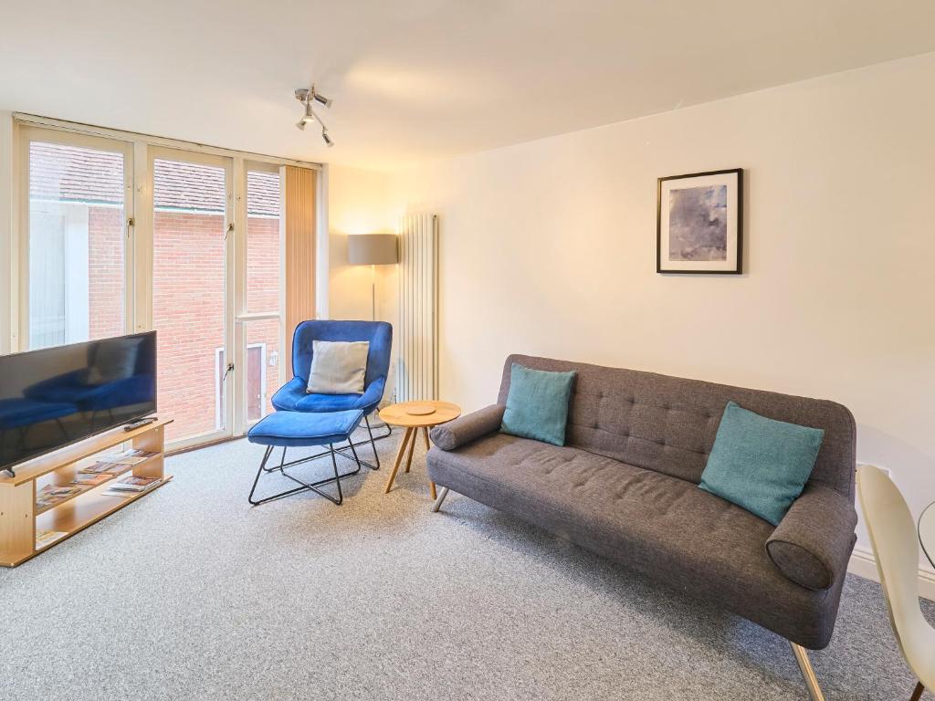 a living room with a couch and a blue chair at Host & Stay - Queen's Corner in Canterbury
