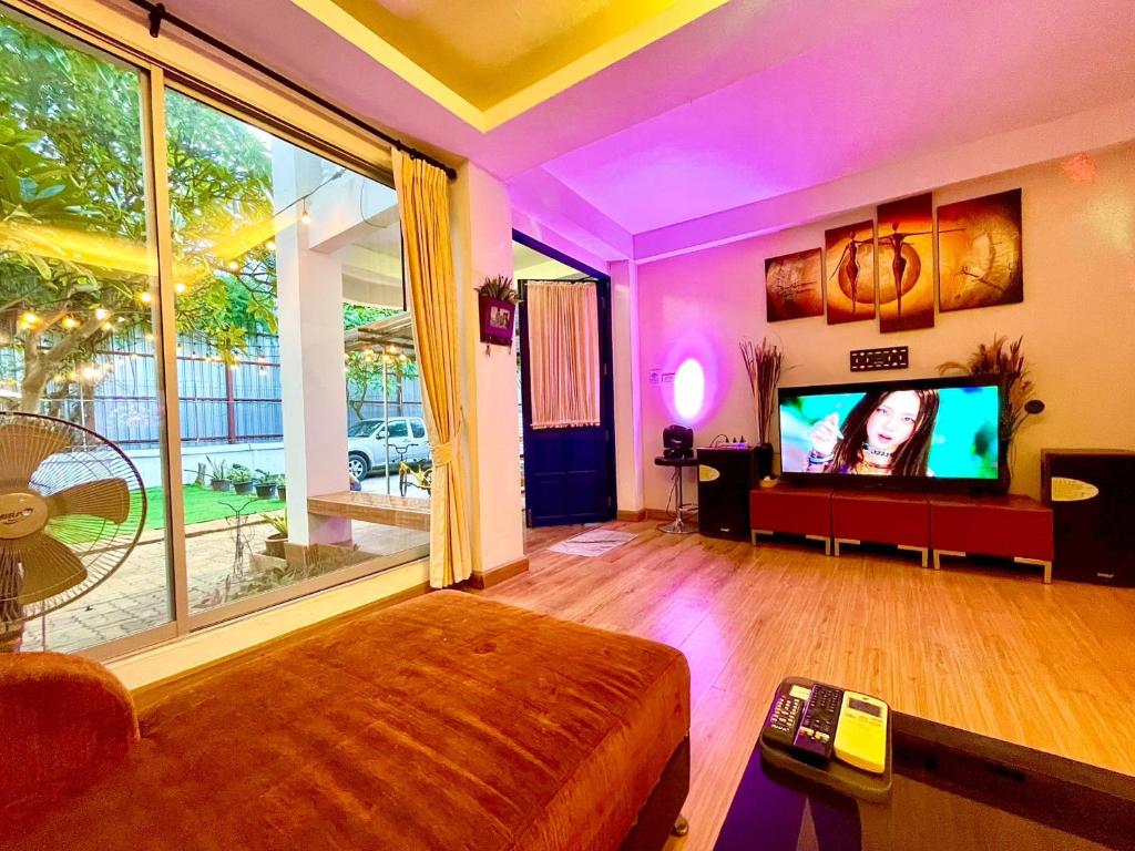 a living room with a large window and a tv at Heartbeat Crypto Jomtien 05 in Jomtien Beach
