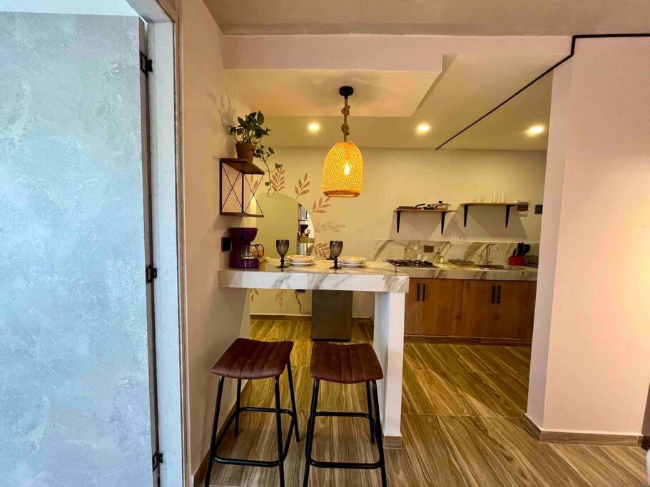 Unique studio with balcony near old town في كارتاهينا دي اندياس: مطبخ مع كونتر وكراسي في غرفة