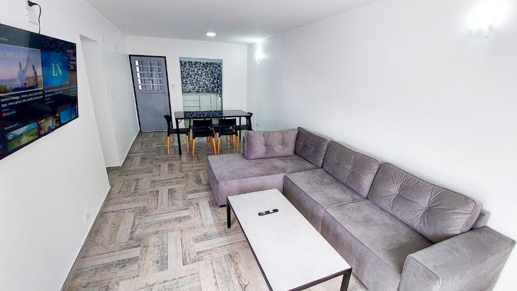 - un salon avec un canapé et une table dans l'établissement Tango Departamento, à Santa Teresita