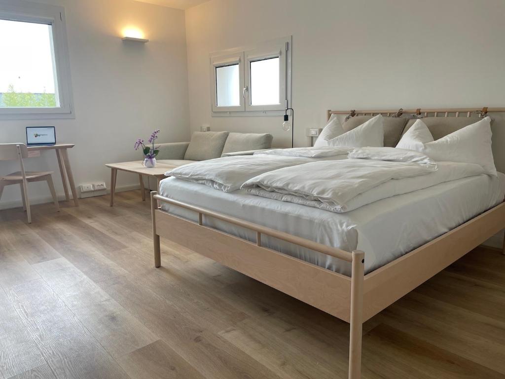 a bedroom with a large bed and a table at Borgo Terra village in Fagagna