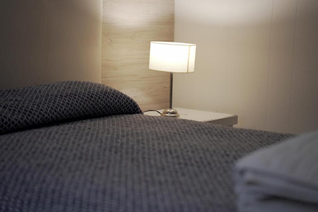 een slaapkamer met een bed en een lamp op een tafel bij Hotel Crystal in Neuquén