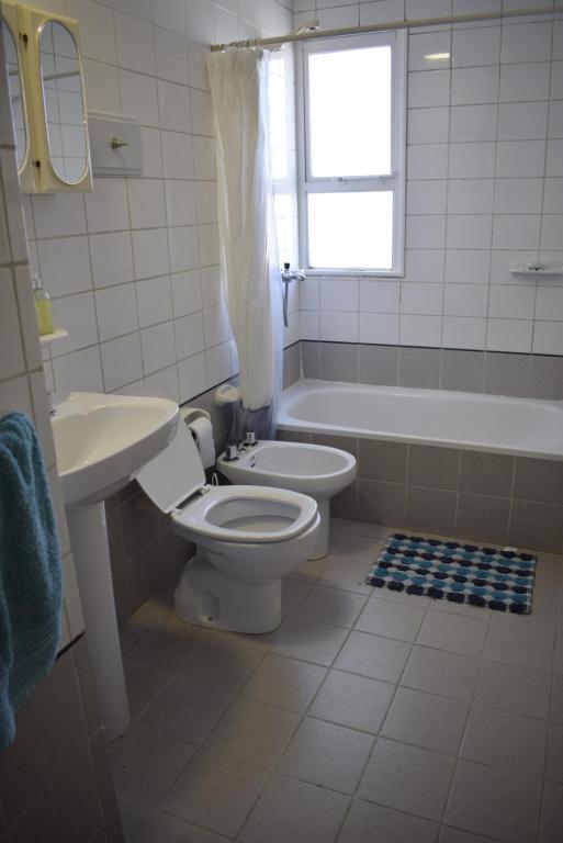 uma casa de banho com um WC, uma banheira e um lavatório. em Amplio Departamento en el corazón de Paraná em Paraná