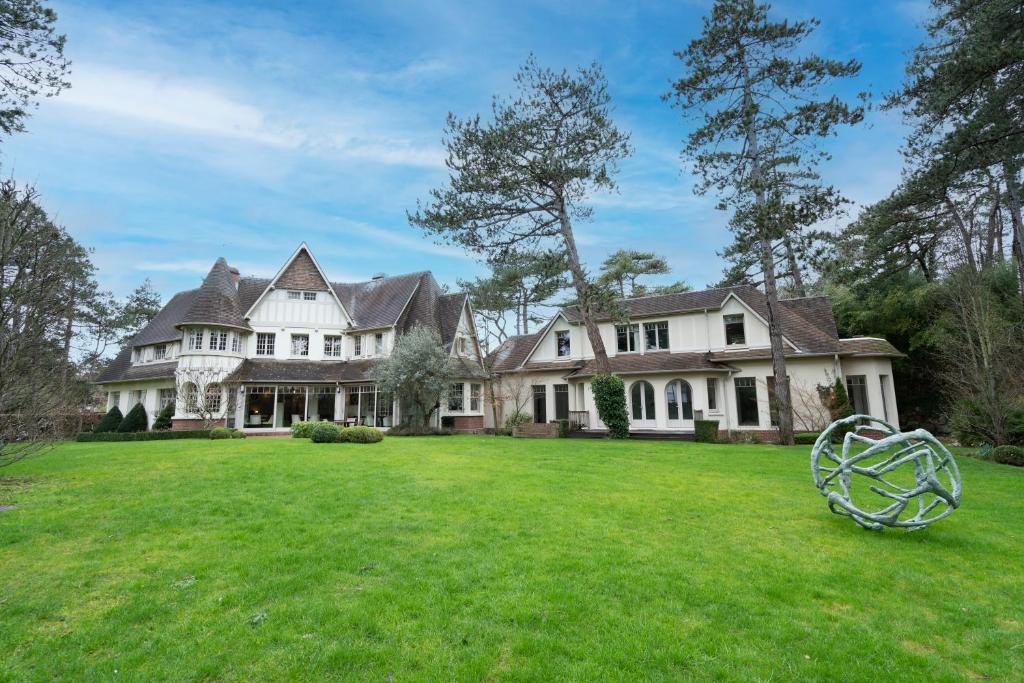 uma grande casa branca com um grande quintal em Demeure d'Hôtes Haec Otia em Le Touquet-Paris-Plage