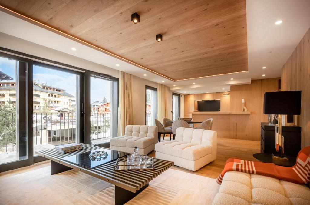 a living room with a couch and a table at EcrinBlanc - Appartement Haut de Gamme - Balcon avec vue - Centre de Megève in Megève