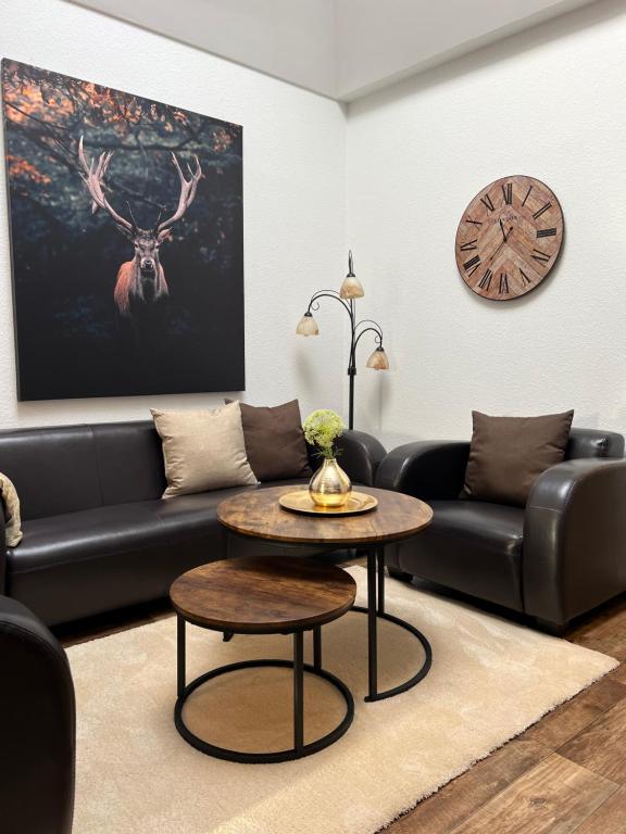 a living room with a couch and a table and a clock at Apartment ZUR ALTEN POST in Osterburg