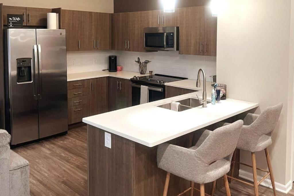 a kitchen with a stainless steel refrigerator and cabinets at New Modern 1 BR in Heart of Midtown in Kansas City