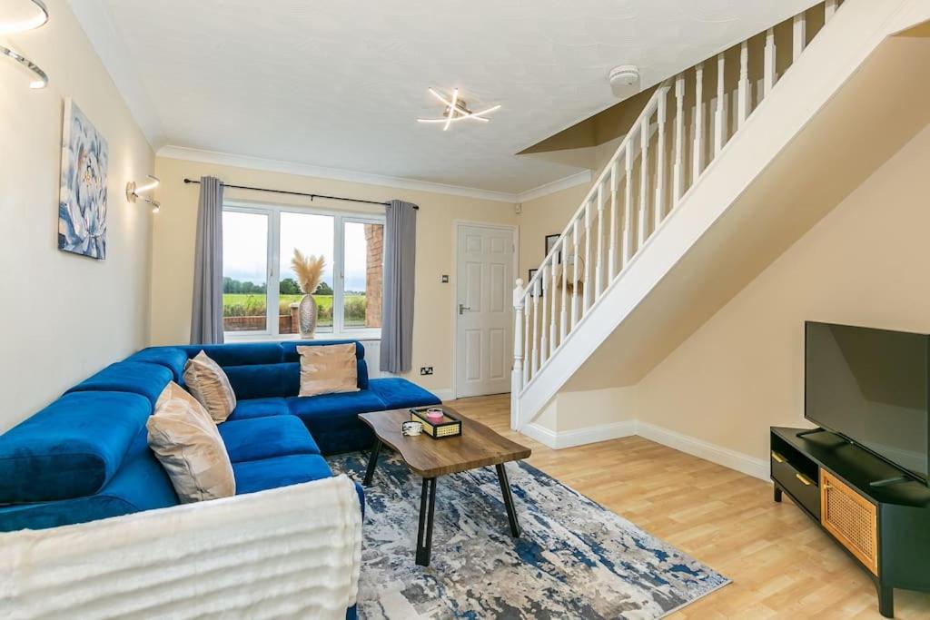 sala de estar con sofá azul y TV en Kime Contractor & Holiday Home, en Lincolnshire
