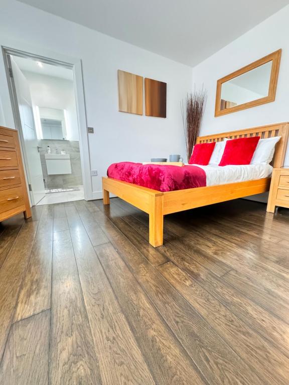 een slaapkamer met een houten bed met rode kussens bij Ideal for Contractors in Reading with Free Parking in Reading