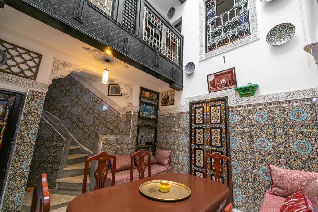 une chambre avec une table, des chaises et un escalier dans l'établissement 105 Kasbah de Boujloud Fes Morocco., à Fès